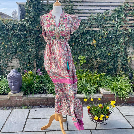 A silk maxi dress with floral print and pink trim, front view